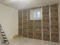 Pose de laine de verre ISOVER en 2 couches sur une structure métallique, avec une fenêtre au centre.