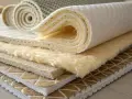 Échantillons de matériaux pour l'isolation textile recyclé, montrant différentes textures et épaisseurs.