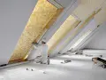 Un ouvrier installe un isolant thermique jaune texturé dans un grenier. C'est le meilleur isolant thermique pour une maison confortable.