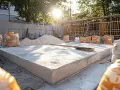 Chantier de terrasse : sacs de matériaux pour terrasse béton, sable et béton frais sous le soleil.