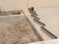 Installation de plusieurs éléments de pose caniveau sur un chantier.