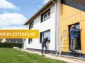 Des ouvriers installent une isolation extérieure sur une maison. Ce chantier modenature ite améliore le confort et l'efficacité énergétique.