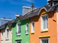 Maisonnettes colorées sous un ciel bleu. Idéal pour refaire sa façade soi-même et égayer son quartier.