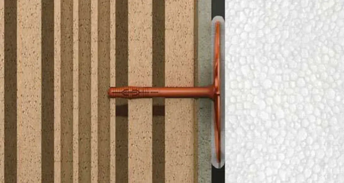 Cheville ite fixée dans un mur isolant en polystyrène expansé, montrant la fixation d'un élément sur une structure isolée.