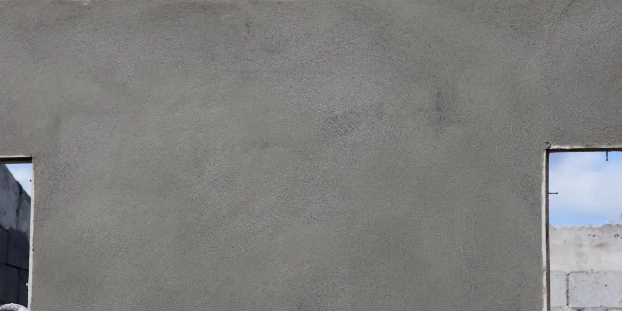 Le ragréage du mur extérieur est presque terminé, offrant une surface lisse et uniforme avant l'application de la finition.