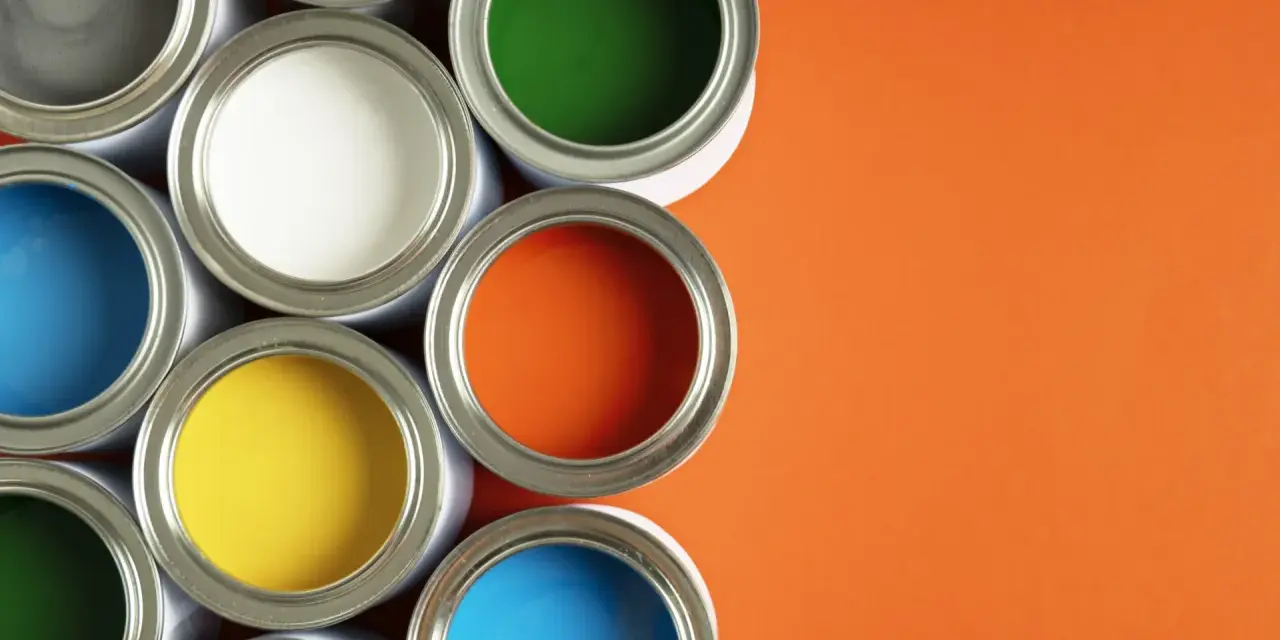 Un assortiment de pots de peinture glycero ou acrylique ouverts, révélant des couleurs vives comme le bleu, le jaune, le rouge, le vert et l'orange sur fond orange.
