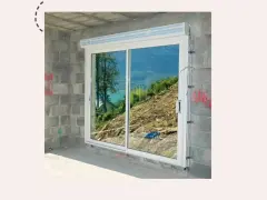 Fenêtre coulissante en PVC installée dans un mur en parpaings, offrant une vue sur un paysage montagneux. Idéal pour apprendre comment poser une fenêtre de toit.