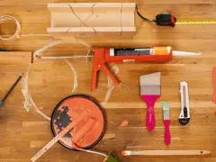 Pistolet à mastic acrylique, rouleau, pinceaux, ruban adhésif, mètre et boîte à onglets pour une utilisation en bricolage.