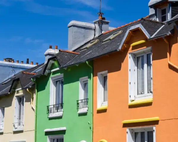 Maisonnettes colorées sous un ciel bleu. Idéal pour refaire sa façade soi-même et égayer son quartier.