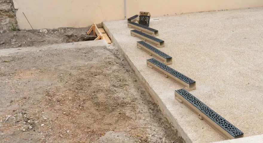 Installation de plusieurs éléments de pose caniveau sur un chantier.
