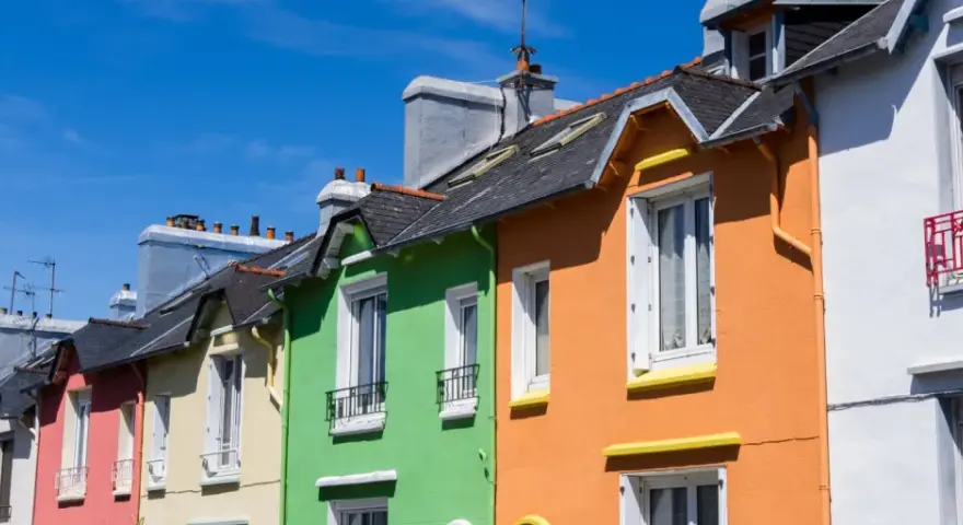 Maisonnettes colorées sous un ciel bleu. Idéal pour refaire sa façade soi-même et égayer son quartier.