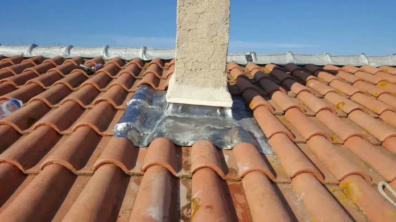 Travaux de toiture : on a choisi d'enlever la cheminée et de laisser le conduit, protégé par un solin en plomb.