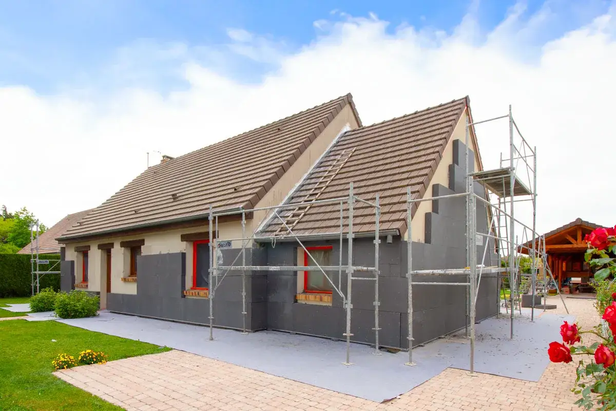 Maison en cours d'isolation ext&eacute;rieure avec panneaux gris. Un chantier qui b&eacute;n&eacute;ficie de la garantie d&eacute;cennale isolation ext&eacute;rieure pour une tranquillit&eacute; assur&eacute;e.