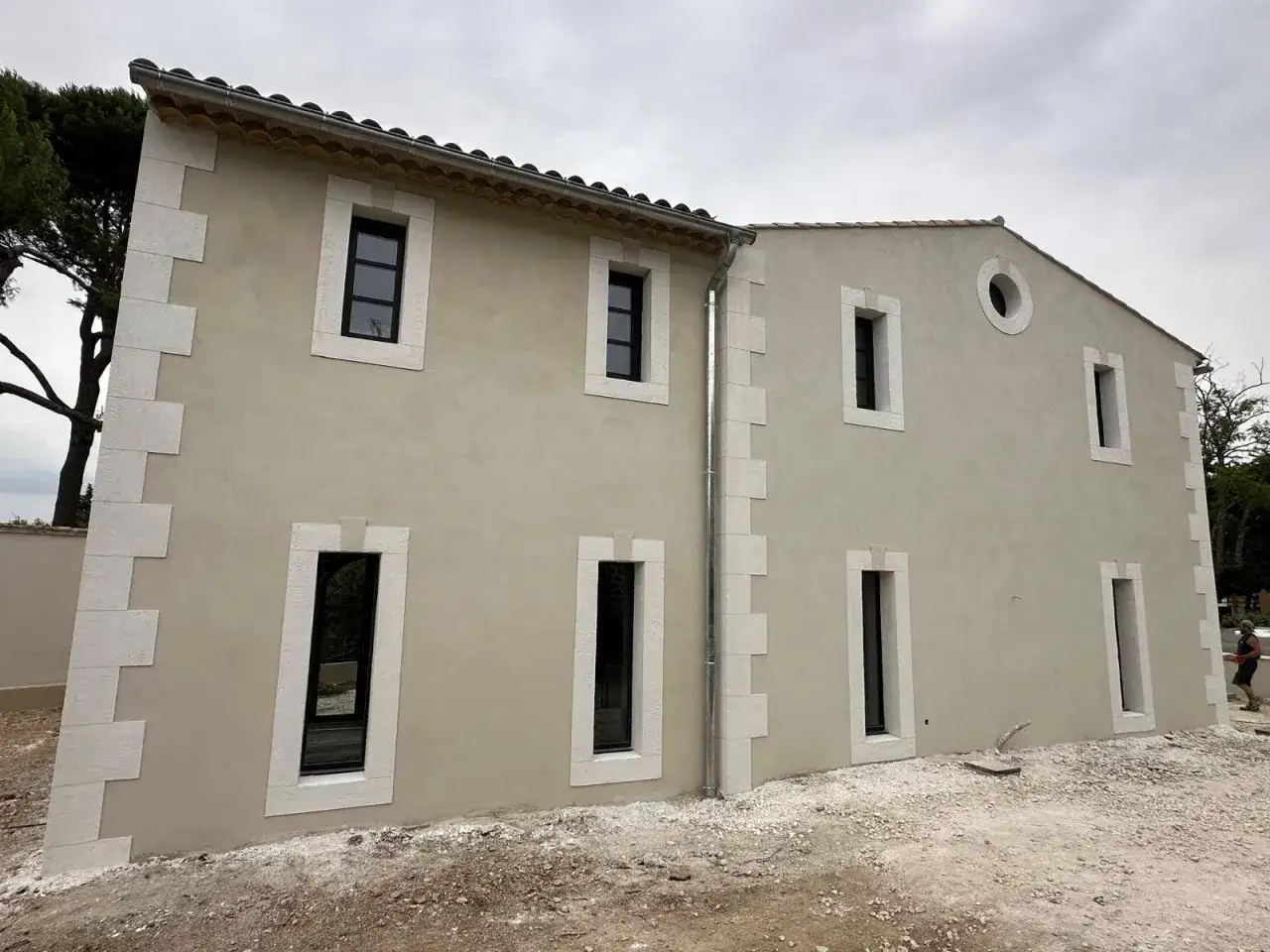 Maison aux pierres de taille, façade claire, fenêtres modernes. Un projet de rénovation qui allie le charme de l'ancien et le confort du modenature ite.