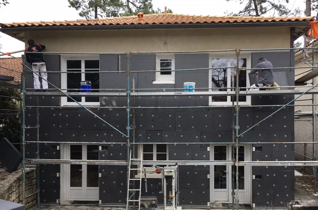 Travaux d'entreprise RGE isolation extérieure : pose de panneaux isolants sur une façade.