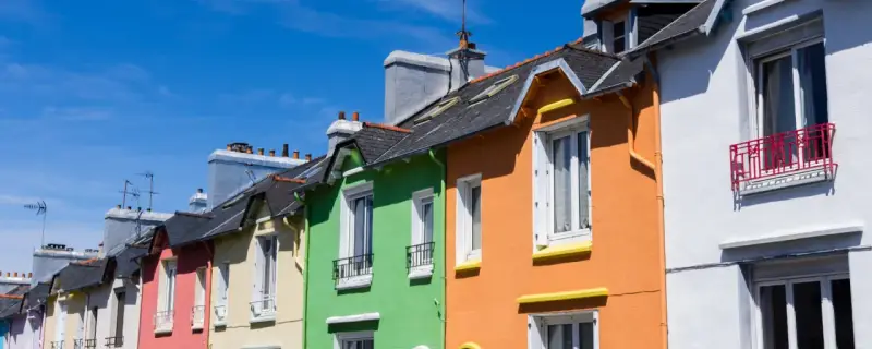 Maisonnettes colorées sous un ciel bleu. Idéal pour refaire sa façade soi-même et égayer son quartier.